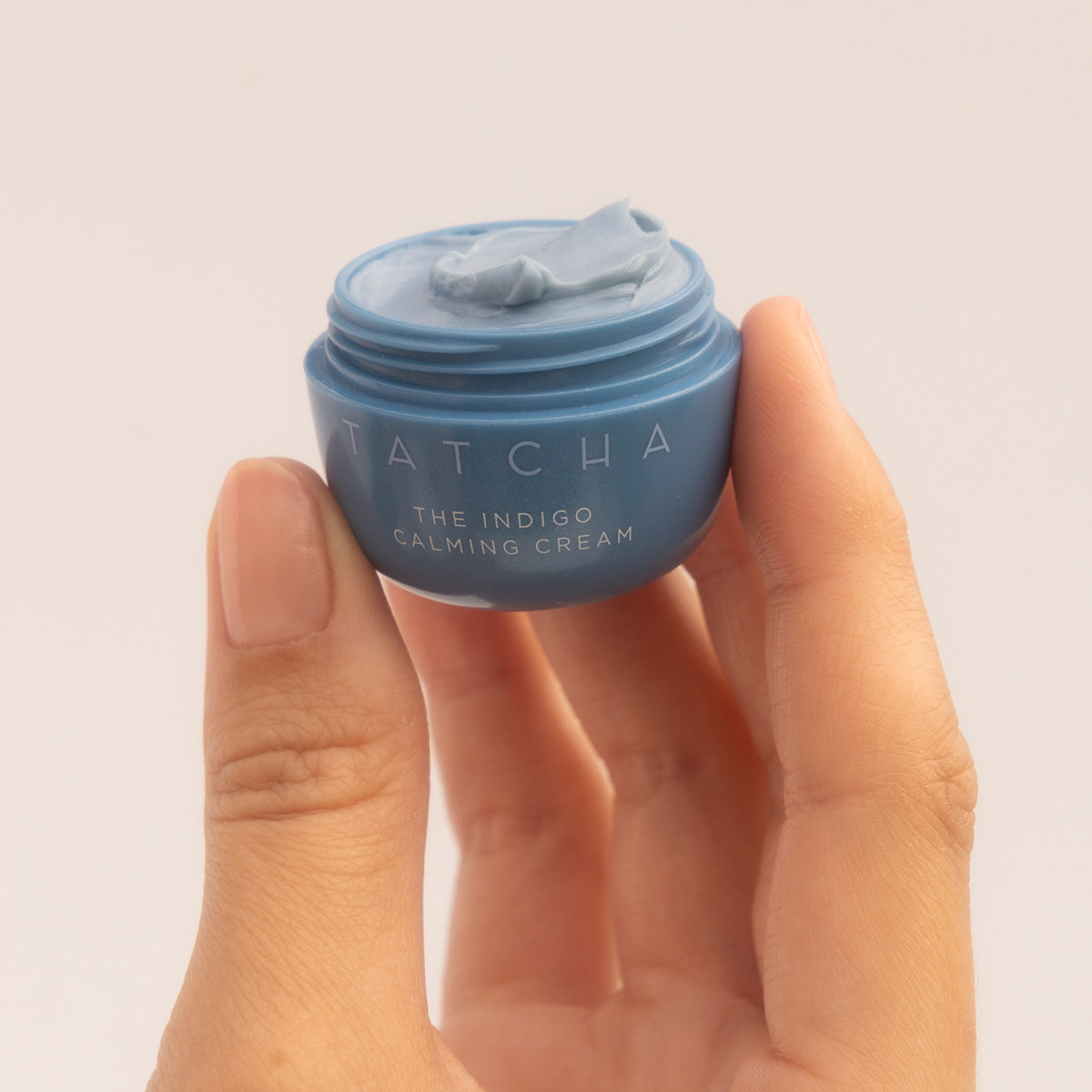 Hand holding mini size Indigo Calming Cream