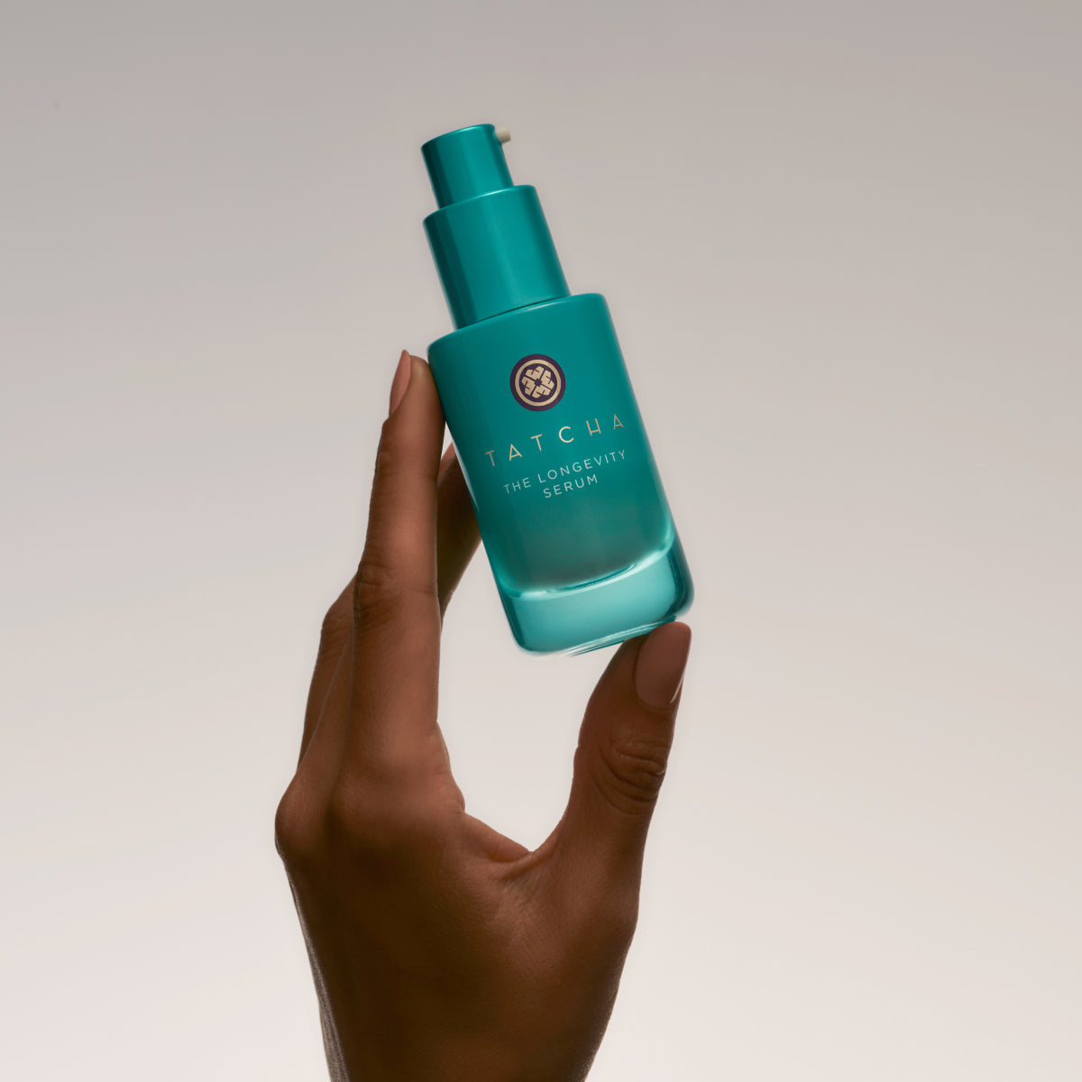Hands holding the Tatcha Longevity Serum